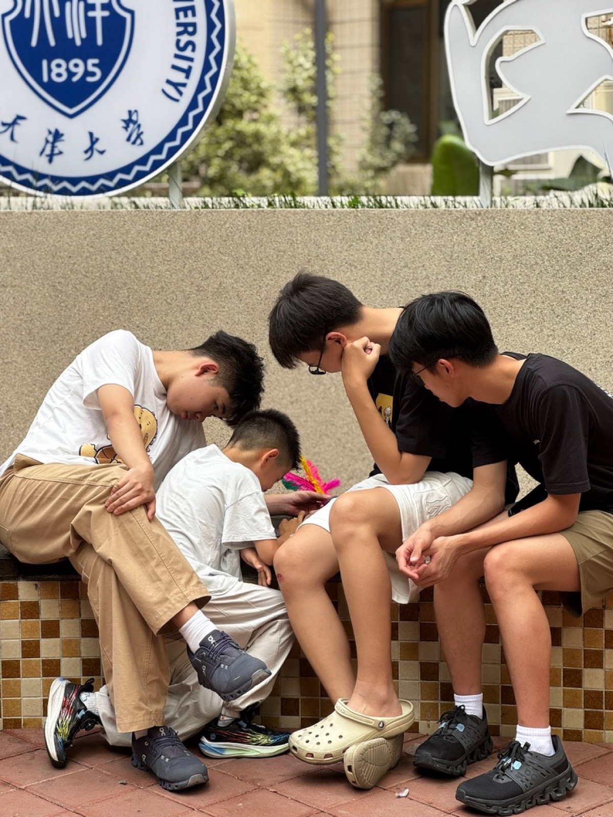 Murid camp MMC bermain di sela kegiatan, di bawah lambang Tianjin University