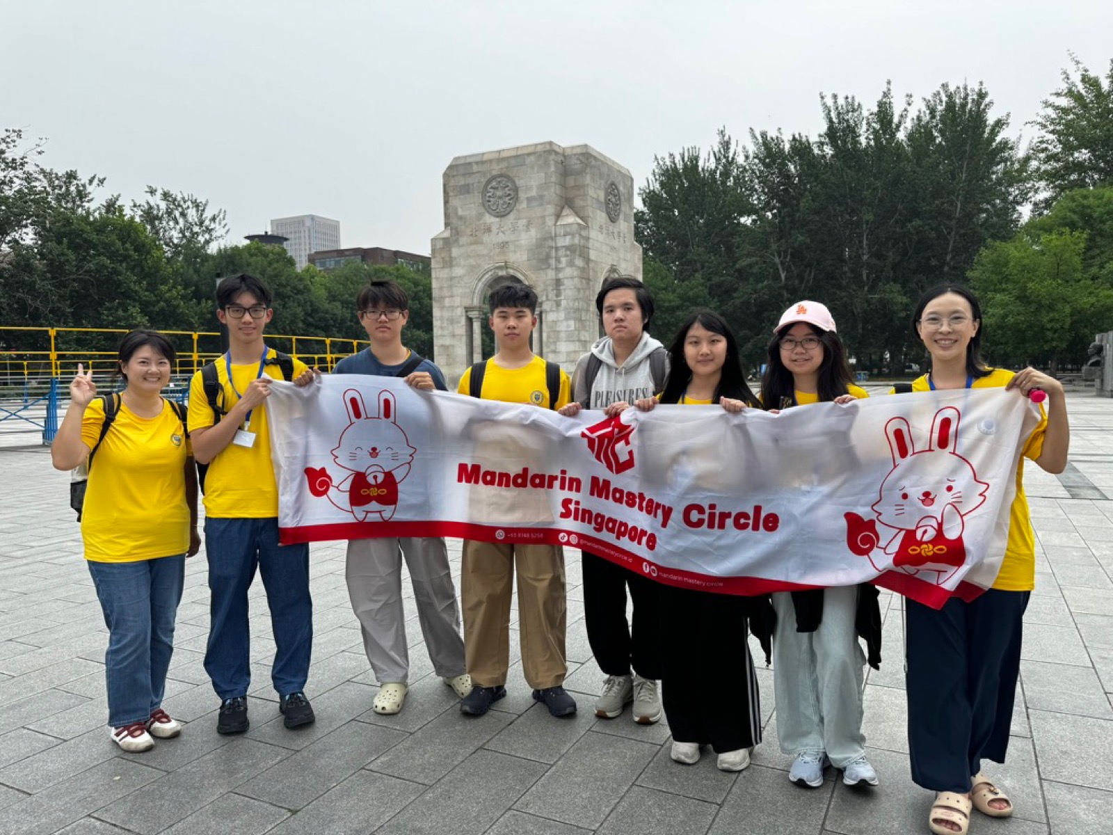 Murid MMC memegang banner Mandarin Mastery Circle Singapore di kampus Tianjin University